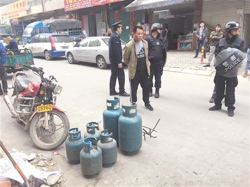 执法人员在仙葫一家“矿泉水店”查获数罐“黑气”，燃气罐罐身破旧（见小图），标识不一